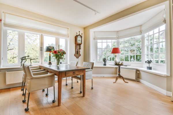 Delightful dining room with a sturdy wooden table and white plush chairs